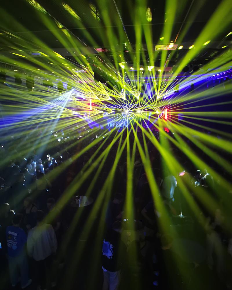 Grün-blaue Laserstrahlen über der feiernden Menge